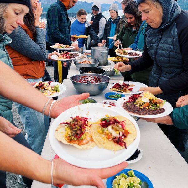 Group gathered at a serving table for tacos in Alaska.
