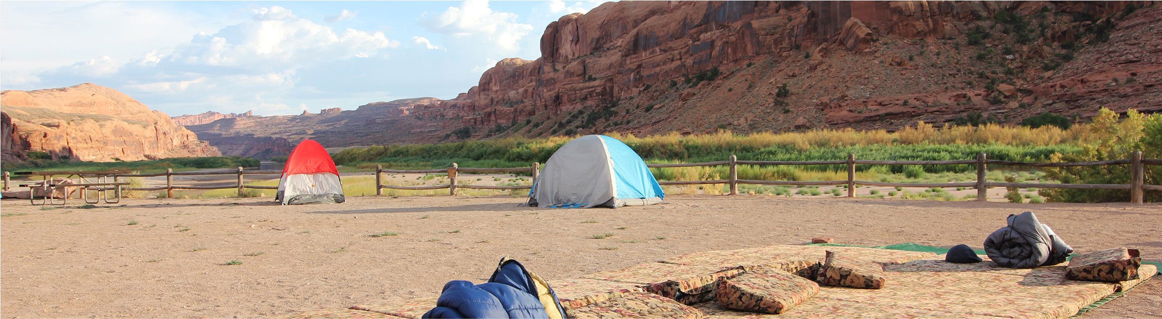 Tents and sleeping bags in a canyon setting on a Green Tortoise adventure