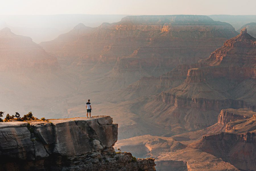 Man stands overlooking the Grand Canyon on the National Parks Loop adventure.