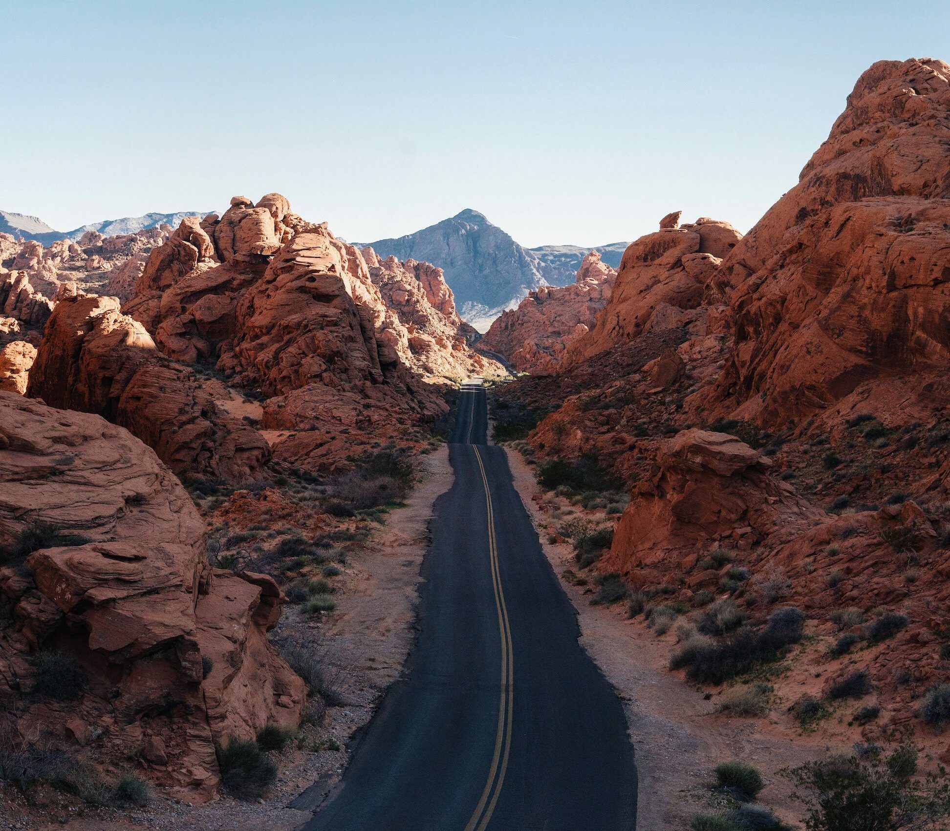 A road stretches through a rocky canyon in the desert.