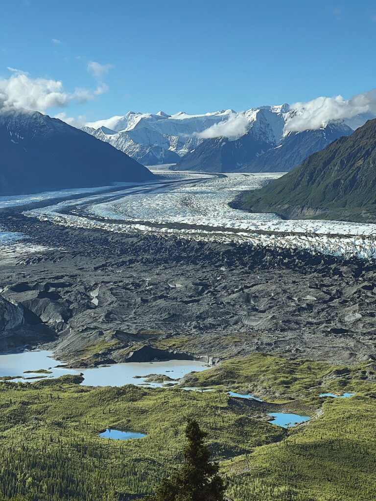 A glacier stretches into the distant mountain range on a group camping tour