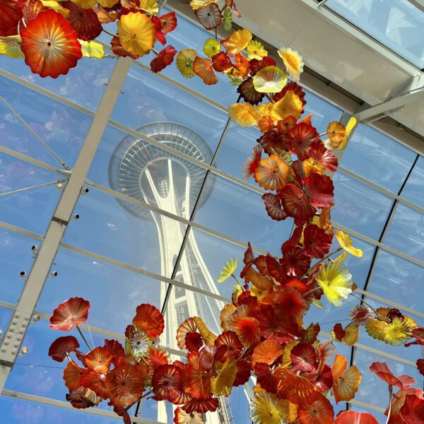 Seattle's Space Needle framed with glass blown flowers viewed from the Chihuly Art Exhibition