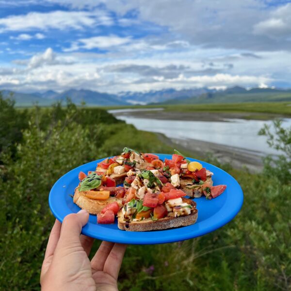 A plate of bruschetta at a campout. Eat delicious meals on the Alaska Experience, a 6-day camping trip.