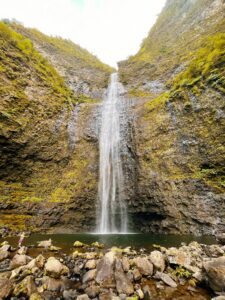 A waterfall cascades into a pool in the tropical rainforest of Kauai