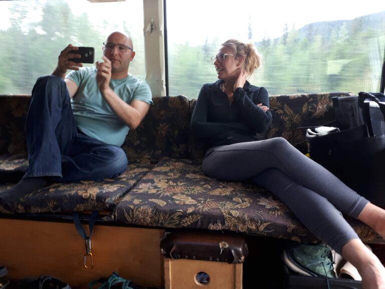 Two people ride on the adventure bus on a 3-day San Francisco to Seattle camping trip.