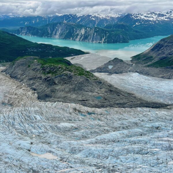 A birds eye view of a glacier feeding into the Taya Inlet with vivid blue waters.