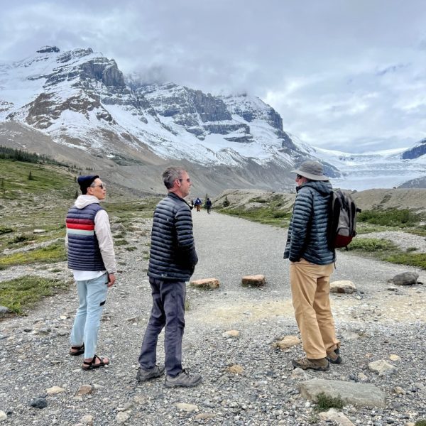 Men chatting with a glacier beyond them in the distance