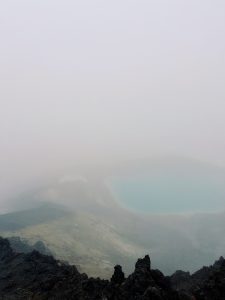 An emerald lake shrouded in fog